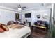 Bright main bedroom featuring a sitting area, a ceiling fan with a chandelier, and hardwood floors at 1547 Paxton Sw Dr, Lilburn, GA 30047