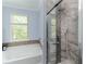 Bathroom featuring a glass-enclosed shower with marble tile surround and a rain shower head at 1547 Paxton Sw Dr, Lilburn, GA 30047