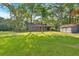 Spacious front yard with lush lawn, a home with a red door and a detached garage at 1731 Maryland Sw Ave, Marietta, GA 30008