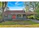 Charming one-story home with a red front door and a covered carport, nestled among mature trees at 1731 Maryland Sw Ave, Marietta, GA 30008