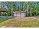A detached three-car garage with white doors and a red roof, set amidst mature trees at 1731 Maryland Sw Ave, Marietta, GA 30008