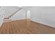 Bright living room featuring newly installed hardwood floors, white walls and staircase access at 1731 Maryland Sw Ave, Marietta, GA 30008