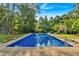 Inviting backyard pool with slide, surrounded by lush greenery and blue skies, perfect for summer fun and relaxation at 1731 Maryland Sw Ave, Marietta, GA 30008
