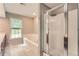 Bathroom includes corner shower, whirlpool tub, white tiled floors, vanity, and window at 245 Sutallee Ridge Ne Ln, White, GA 30184