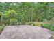 Stone patio with outdoor seating surrounded by lush greenery and mature trees, offering a serene outdoor space at 245 Sutallee Ridge Ne Ln, White, GA 30184