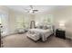 Bedroom featuring carpet, a ceiling fan, two bedside tables, and a bench at the foot of the bed at 4457 Equity Ct, Ellenwood, GA 30294
