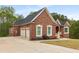 Charming brick home with a three-car garage, manicured landscaping, and a well-maintained lawn at 4457 Equity Ct, Ellenwood, GA 30294