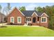 Beautiful brick home featuring a manicured lawn and charming architectural details at 4457 Equity Ct, Ellenwood, GA 30294