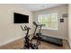 Home gym with exercise bike, treadmill, large window for natural light, and wall-mounted TV at 4457 Equity Ct, Ellenwood, GA 30294