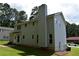 A sprawling backyard view reveals lots of green space on a sunny day, chimney, and a door to access the property at 1471 Ashwood Way, Lawrenceville, GA 30043