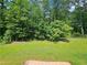 Expansive backyard featuring a lush lawn and mature trees offering privacy and shade at 1471 Ashwood Way, Lawrenceville, GA 30043