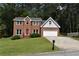 Traditional two-story brick house with a manicured front lawn, a red front door, and an attached two-car garage at 1471 Ashwood Way, Lawrenceville, GA 30043