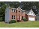 Inviting two-story brick house with light grey siding, a red door, well-kept lawn, and an attached two-car garage at 1471 Ashwood Way, Lawrenceville, GA 30043