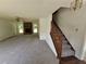 A large open living room with new grey carpet, fireplace, and a staircase with wood railing at 1471 Ashwood Way, Lawrenceville, GA 30043
