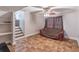 Inviting basement area with tile floors, a ceiling fan, and a comfortable sitting area near the staircase at 2320 Boone Pl, Snellville, GA 30078