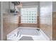 Bathroom features a relaxing tub with a window, stylish tile, and good lighting at 2320 Boone Pl, Snellville, GA 30078
