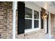 Exterior brick wall with black shutters and a white pillar, showcasing the home's classic architectural elements at 4059 Canby Ln, Decatur, GA 30035