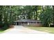 Single-story home with a long driveway and lots of mature trees at 4059 Canby Ln, Decatur, GA 30035