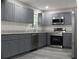 Modern kitchen featuring gray cabinets, stainless steel appliances, and granite countertops at 4059 Canby Ln, Decatur, GA 30035