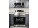 Stainless steel Samsung range and microwave compliment gray cabinets and modern countertop at 4059 Canby Ln, Decatur, GA 30035