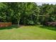 Large, grassy backyard surrounded by trees, offering privacy and ample space for recreation at 2113 Soque River Dr, Duluth, GA 30097