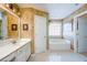 Bright bathroom featuring a soaking tub, double vanity, white cabinets, and stylish fixtures at 2113 Soque River Dr, Duluth, GA 30097