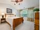 Warm bedroom showcasing a wooden bed frame, neutral tones, and bright natural light at 2113 Soque River Dr, Duluth, GA 30097