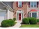 Inviting front entrance featuring a red door with white trim, brick accents, and manicured landscaping at 2113 Soque River Dr, Duluth, GA 30097