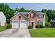 Charming two-story home featuring a two-car garage, brick accents, and a well-manicured front lawn at 2113 Soque River Dr, Duluth, GA 30097