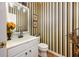 Stylishly decorated powder room with a modern vanity, decorative mirror and framed wall art at 2113 Soque River Dr, Duluth, GA 30097
