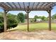 A wooden pergola provides a view of the green backyard and fence at 3340 Deerwood Ln, Rex, GA 30273
