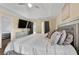 Bright bedroom featuring a tray ceiling, a ceiling fan, large windows, and a TV at 3340 Deerwood Ln, Rex, GA 30273