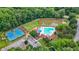 Aerial view of community pool with tennis courts, lounge chairs, and a pond in a wooded neighborhood at 3340 Deerwood Ln, Rex, GA 30273