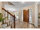 Bright foyer with hardwood floors, wooden staircase, and a view into the dining room at 3340 Deerwood Ln, Rex, GA 30273