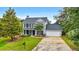 Traditional two-story home with a two car garage and mature landscaping on a sunny day at 3340 Deerwood Ln, Rex, GA 30273
