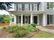 View of the front porch with white columns and black shutters on a sunny day at 3340 Deerwood Ln, Rex, GA 30273