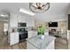 Modern kitchen featuring granite countertops, white cabinetry, and stainless steel appliances open to the living room at 3340 Deerwood Ln, Rex, GA 30273