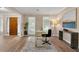 Bright office space featuring hardwood floors, two windows, a gold desk, and stylish decor at 3340 Deerwood Ln, Rex, GA 30273