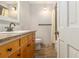 This full bathroom features a wood vanity with a stone countertop, a tiled floor and combination shower and tub at 4819 Elam Rd, Stone Mountain, GA 30083