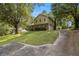 View of home with a concrete driveway leading to a two-car garage, complemented by mature trees and lush greenery at 4819 Elam Rd, Stone Mountain, GA 30083