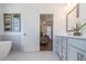 Bright bathroom featuring modern cabinets, white countertops, and an open doorway to the living area at 1011 Crown Oak St # 47, Johns Creek, GA 30022