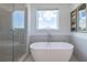 Bright bathroom featuring a standalone tub with a sleek faucet and a glass-enclosed shower at 1011 Crown Oak St # 47, Johns Creek, GA 30022