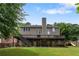 Back exterior view of the home showcasing the spacious deck, patio, and backyard with a slide at 141 Ennisbrook Se Dr, Smyrna, GA 30082