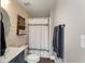 Charming bathroom with wood paneling, decorative shelves, and elegant shower curtain at 141 Ennisbrook Se Dr, Smyrna, GA 30082