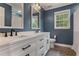 Stylish blue bathroom featuring a double vanity, quartz countertop, modern fixtures, toilet, and tiled shower at 141 Ennisbrook Se Dr, Smyrna, GA 30082