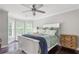 Bright bedroom featuring a ceiling fan, hardwood floors, and bay windows that offer ample natural light and an outside view at 141 Ennisbrook Se Dr, Smyrna, GA 30082