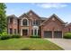 Elegant two-story red brick home featuring a well-manicured lawn and attached two-car garage at 141 Ennisbrook Se Dr, Smyrna, GA 30082
