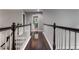 Long hallway featuring wood floors and white railings with view to a bathroom at the end at 141 Ennisbrook Se Dr, Smyrna, GA 30082