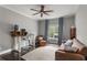 Comfortable home office with a wooden desk, brown sofa, and stylish ceiling fan at 141 Ennisbrook Se Dr, Smyrna, GA 30082
