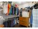 Organized walk-in closet with shelves, hanging rods, dark wood floor, and a wood dresser for storage at 141 Ennisbrook Se Dr, Smyrna, GA 30082